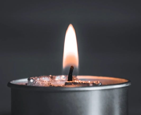 Lit candle in a calm setting symbolizing unity and guidance for cremation services Mount Holly, NJ.