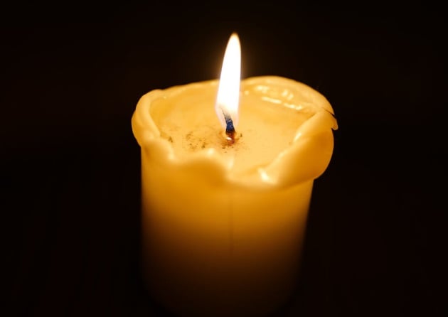 Single candle with a soft glowing flame, creating a quiet and reflective memorial setting in Eastampton Township, NJ.