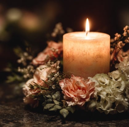 Lit candle with flowers representing cremation services in Mount Holly, NJ.